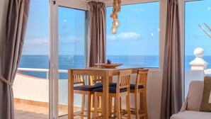 A dining area with a table and chairs, a hanging light fixture, and a view of the sea through large windows. - Villa Blanca Callao Salvaje. First line by the sea (Callao Salvaje)