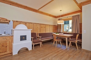 A cozy room with a wooden bench, a table, and a built-in oven. - Das Hopfgarten Aparthotel (Hopfgarten im Brixental)