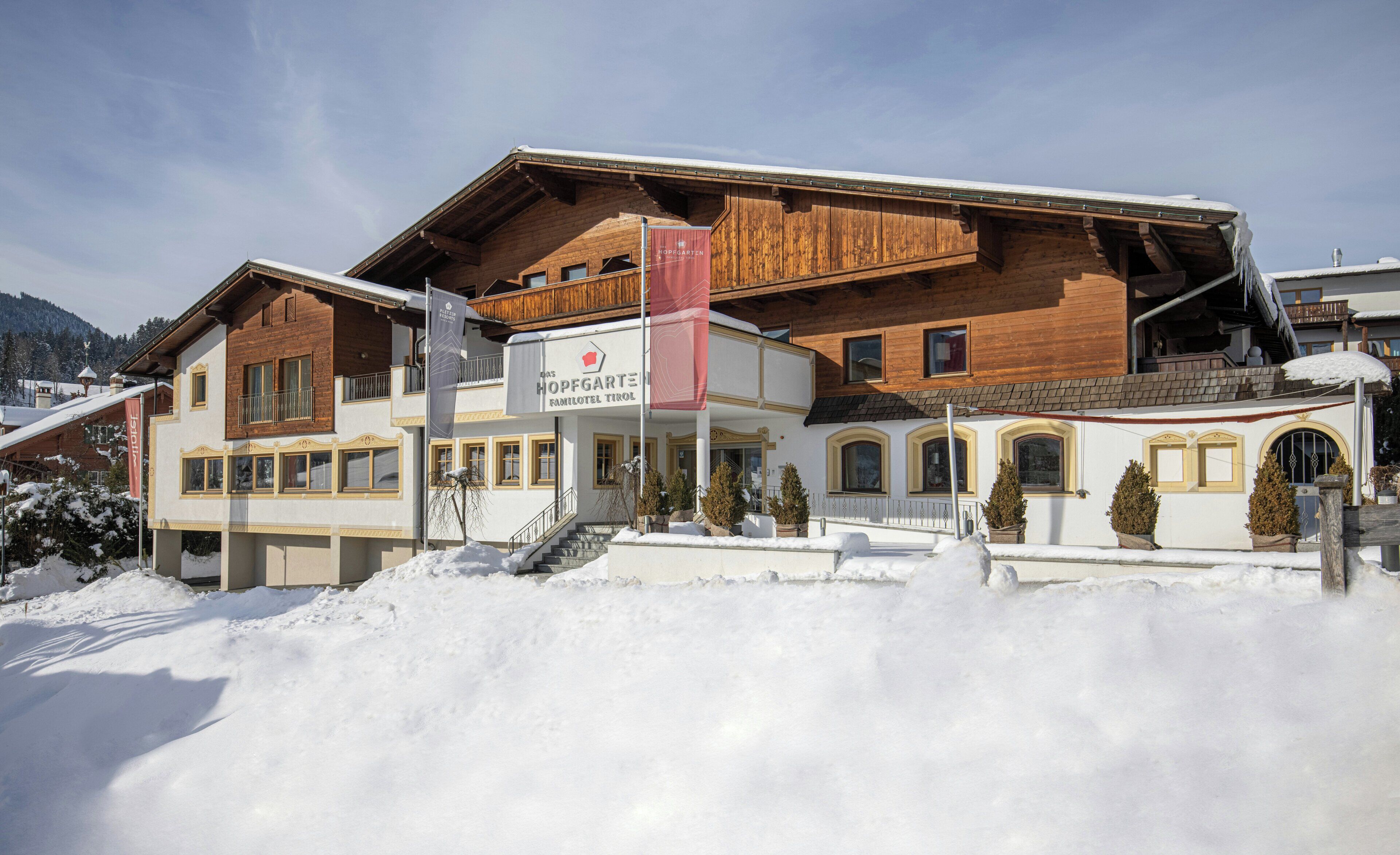 A hotel with a wooden facade, a balcony, and a sign indicating it is a family hotel.