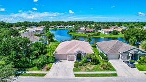 A residential area with houses, a lake, and a clear sky.