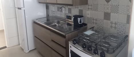 A kitchen with white cabinets, a stove, and a refrigerator.
