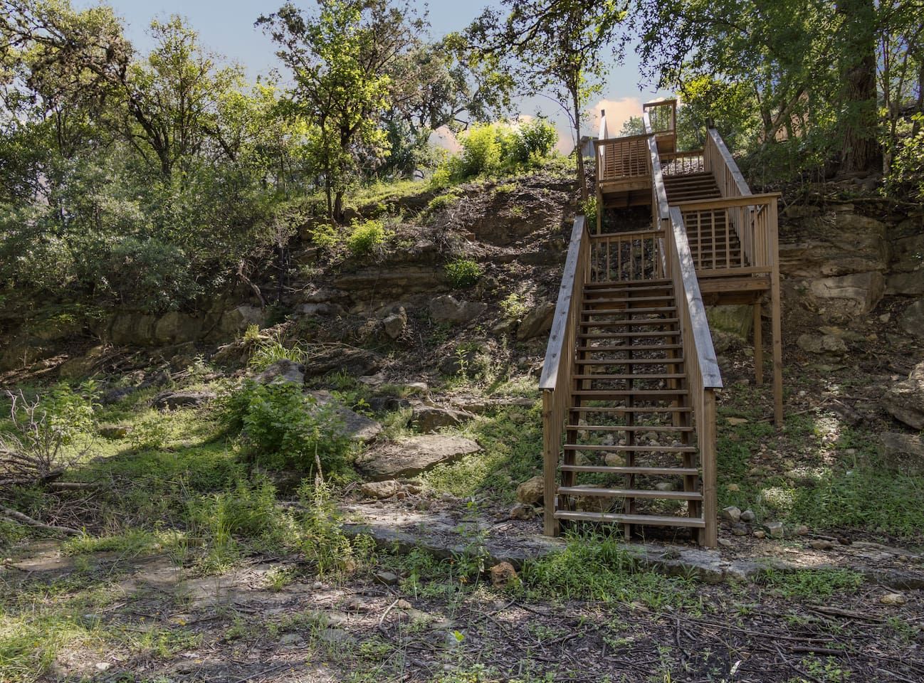 A wooden staircase leading up a rocky hillside.