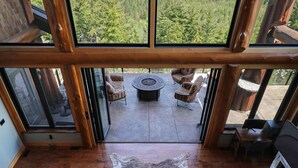 A spacious living area with a large window offering a view of a forested landscape.