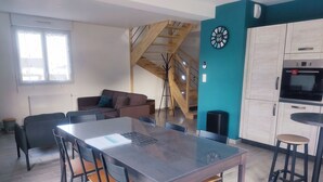 A modern kitchen with a built-in oven and a dining area with a large table and chairs.