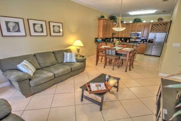 A living room with a sofa, coffee table, and dining area.