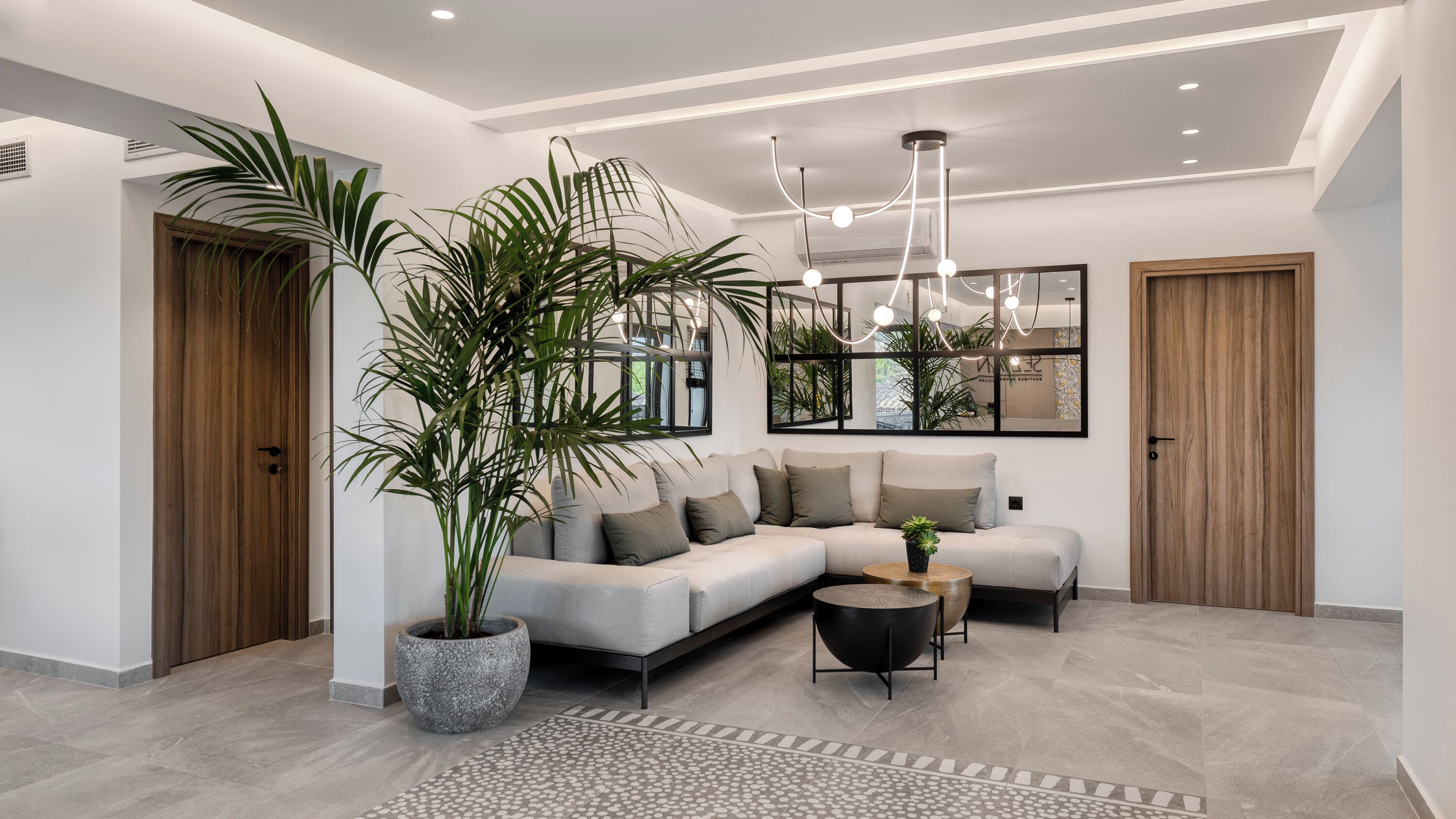 A modern living room with a sectional sofa, a coffee table, and a large potted plant.