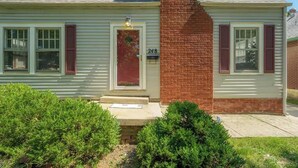 A two-story house with a red door, white shutters, and a brick chimney. - 3 Bed 1.5 Bath Home By College Hill & Hospitals (Wichita)