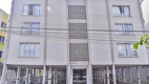 Un edificio a più piani con grate alle finestre e un ingresso centrale.