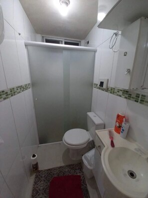 Ein kleines Badezimmer mit Toilette, Waschbecken und Dusche.