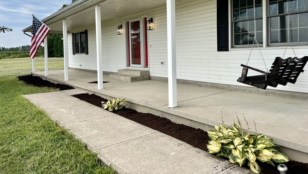 A white house with a porch, an American flag, and a swing. - Peaceful Farmhouse & Rural Views (Sabina)