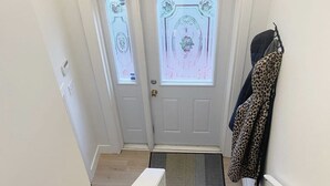 Eine Treppe führt zu einer Tür mit Milchglasfenstern und einer Fußmatte.