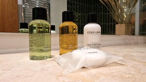 Three bottles of body wash and a bar of soap on a marble surface. - Stunning Luxury 2 Bed City Centre Apartment (Derby)
