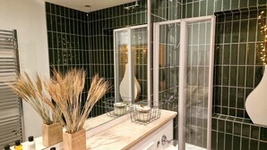 A bathroom with a large mirror, dark green tiled walls, a wooden vanity, and a glass shower enclosure. - Stunning Luxury 2 Bed City Centre Apartment (Derby)