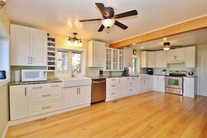 Enjoy cooking in this well-equipped kitchen with a central island, microwave, oven, and various appliances.
