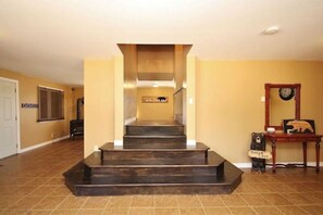 Staircase leads to an upper floor with a door and window in view.
