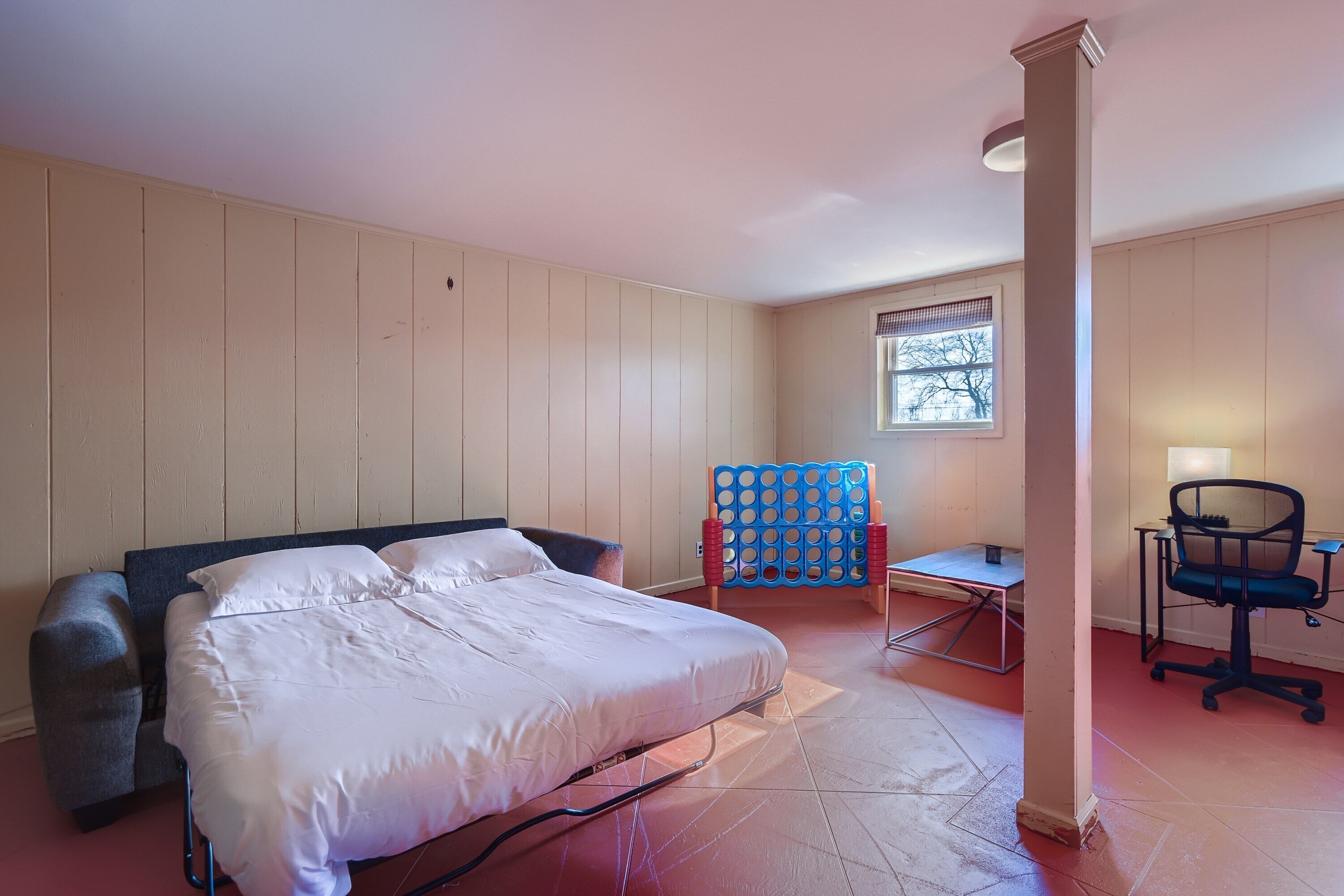 Ein Zimmer mit einem Bett, einem Schreibtisch und einem Stuhl.