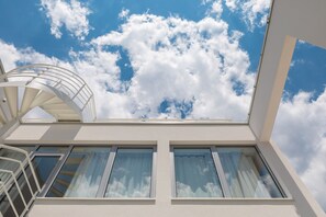 A modern building with a skylight and two windows with curtains.