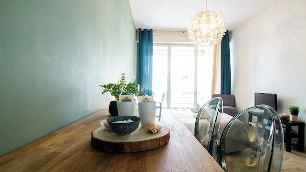 A dining area with a wooden table, clear glass chairs, a bowl, and potted plants. - Reve de Jade devant le canal (Annecy)