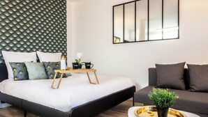 A modern bedroom with a bed, bedside table, and a small potted plant. - Biloba du Lac (Annecy)