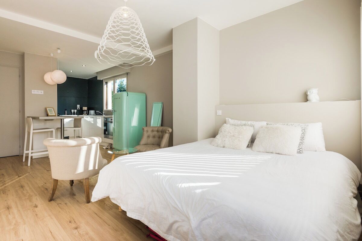 Een moderne slaapkamer met een groot bed, een bureau en een stoel.