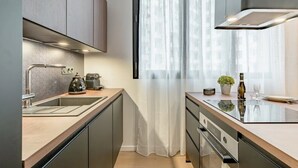A modern kitchen with a built-in oven, a coffee machine, and a sink. - Loge Galeries Lafayette 1 min lac (Annecy)