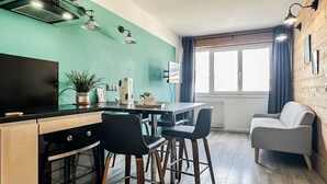 A compact kitchen with a dining area, a sofa, and a TV. - Etoile des neiges 2 min du centre (Annecy)