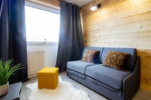 Relax in this inviting space with a comfortable sofa, ottoman, and plush rug.