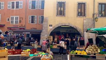 Een levendige openbare markt met verkopers die fruit en groenten verkopen.