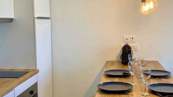 A dining area with a wooden table set for four, including plates and wine glasses.