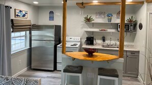 Une cuisine de taille réduite avec un îlot central, un réfrigérateur, une cuisinière et un four à micro-ondes.