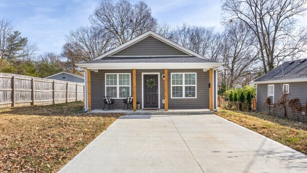 A single-story house with a front porch, a garage, and a small front yard. - Sleeps 8. Cozy Bungalow in Downtown Georgetown (Georgetown)