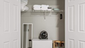 A compact room with a white wardrobe, a small heater, and a shelf with folded towels and toiletries. - Sleeps 8. Cozy Bungalow in Downtown Georgetown (Georgetown)