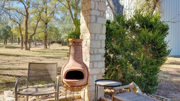 An outdoor seating area with a stone pillar, a bench, and a rustic clay oven. - Georgetown Barn Studio on > 7 Acres: Pet Friendly! (Georgetown)