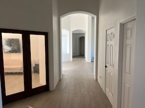 Stylish hallway with a herringbone-patterned floor and simple white doorways.