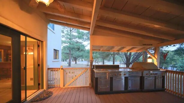 A covered outdoor area with a built-in grill and sliding glass doors leading to a room. - Let's Birdie!! (Alto)