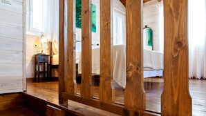 Un escalier en bois mène à une chambre à coucher qui contient un lit et une table de chevet.
