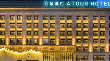 Un hotel de varios pisos con una entrada destacada y señalización iluminada.