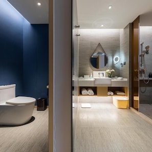 A modern bathroom with a freestanding bathtub, a vanity with a mirror, and a shower area. - Atour Hotel (Ma'anshan)