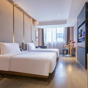 A hotel room with a large bed, a desk with a chair, a television, and a window with curtains. - Atour Hotel (Ma'anshan)