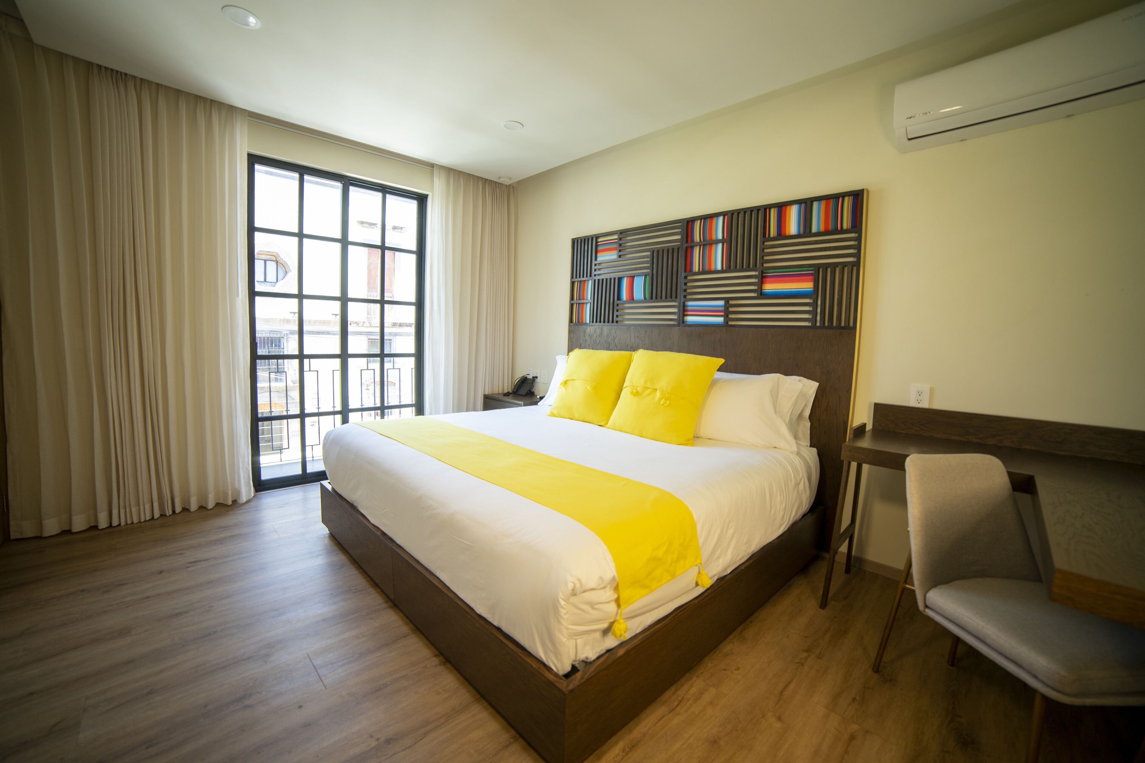 Una habitación de hotel moderna con una cama grande, un escritorio y una silla.
