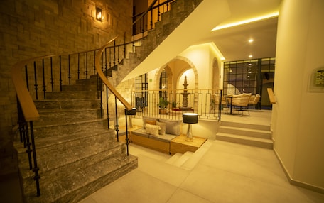 A spacious interior with a grand staircase, a cozy seating area, and a well-lit atrium.