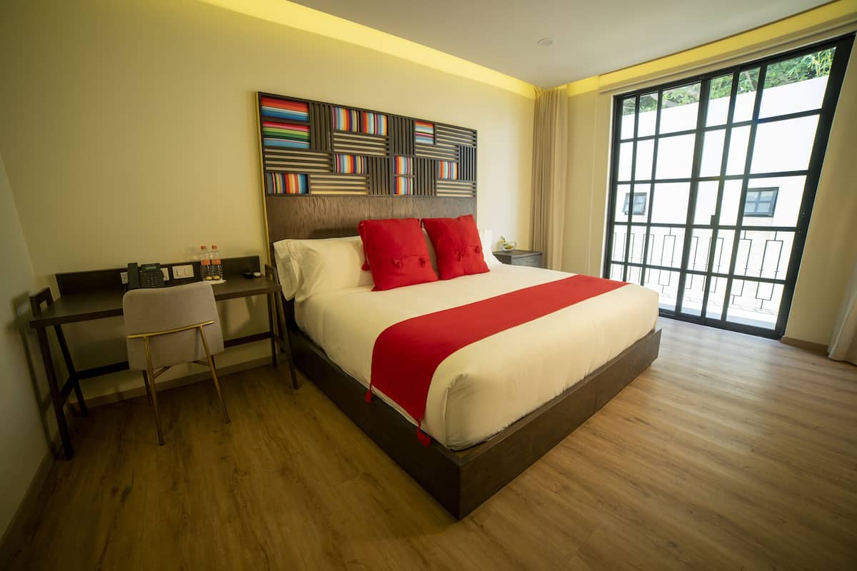 Una habitación de hotel moderna con una cama grande, un escritorio y una silla.
