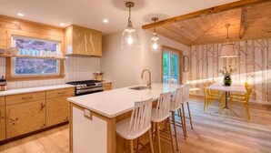 A modern kitchen with wooden cabinetry, a central island, and pendant lighting.