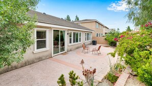 A residential building with a patio area, sliding glass doors, and outdoor seating.