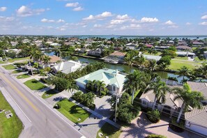 An aerial view of a coastal residential area with houses, a marina, and a bridge in the background. - Enjoying paradise on Marco Island with direct access! (Marco Island)