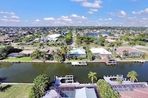 A residential area with a large body of water, docks, and houses with green lawns and palm trees. - Enjoying paradise on Marco Island with direct access! (Marco Island)
