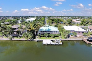 A waterfront property with a large dome structure, a dock, and surrounding greenery. - Enjoying paradise on Marco Island with direct access! (Marco Island)