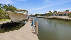 A boat docked at a marina with a wooden walkway leading to it. - Enjoying paradise on Marco Island with direct access! (Marco Island)