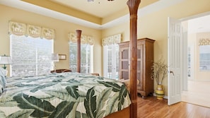 A bedroom with a large bed, wooden floor, and a wooden wardrobe. - Enjoying paradise on Marco Island with direct access! (Marco Island)