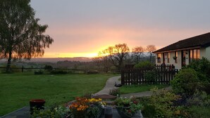A house with a garden and a view of the sunset. - The Rock Self Catering Holiday Accommodation (Coleford)
